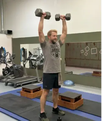 man performing shoulder presses